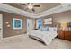 Comfortable primary bedroom with a tray ceiling and a view of the ensuite bathroom at 19973 W 94Th Ln, Arvada, CO 80007