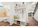 Bright mud room featuring a bench, hooks, and decorative storage crates next to a bathroom with wood-look flooring at 19973 W 94Th Ln, Arvada, CO 80007