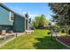 The large backyard features a cozy sitting area, lush lawn and a vegetable garden at 8370 W Evans Pl, Lakewood, CO 80227