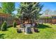 Outdoor relaxation with a patio set under a metal arbor, surrounded by lush greenery and a hammock nearby at 8370 W Evans Pl, Lakewood, CO 80227