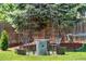 Backyard patio set under a metal arbor offers relaxation, surrounded by greenery and a hammock nearby at 8370 W Evans Pl, Lakewood, CO 80227