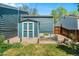 Backyard view featuring a small shed, greenery, and a decorative water feature with a gravel surround at 8370 W Evans Pl, Lakewood, CO 80227