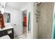 Well-lit bathroom with tiled shower, modern fixtures, and a doorway to the bedroom at 8370 W Evans Pl, Lakewood, CO 80227