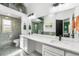 Bathroom featuring double sinks with a quartz countertop, large mirror and a glass-door shower at 8370 W Evans Pl, Lakewood, CO 80227