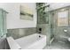 Bathroom featuring a glass-door shower and a bathtub at 8370 W Evans Pl, Lakewood, CO 80227