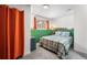 Inviting bedroom featuring soft carpet, a bed with plaid comforter, and orange curtains at 8370 W Evans Pl, Lakewood, CO 80227