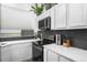 Modern kitchen featuring white cabinets, sleek countertops, and stainless steel appliances, creating a clean and efficient cooking space at 8370 W Evans Pl, Lakewood, CO 80227