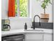 Well-lit kitchen with white countertops, modern faucet, and a view from the window, enhancing the cooking experience at 8370 W Evans Pl, Lakewood, CO 80227