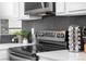 Modern kitchen featuring sleek countertops, a stylish backsplash, and stainless steel appliances for a contemporary cooking experience at 8370 W Evans Pl, Lakewood, CO 80227
