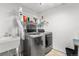 Functional laundry room featuring updated washer and dryer, storage shelves, and a utility sink at 8370 W Evans Pl, Lakewood, CO 80227