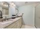 Bathroom featuring double sinks, granite countertops, and a glass-enclosed shower at 7877 E Mississippi Ave # 506, Denver, CO 80247