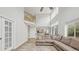 Open-concept living area with vaulted ceilings, a fireplace, large windows, and a comfortable sectional sofa at 10052 Sage Sparrow Ct, Highlands Ranch, CO 80129