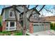 Two-story house with brick details, a tree in the yard, and a well-kept lawn at 10052 Sage Sparrow Ct, Highlands Ranch, CO 80129