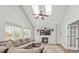 Vaulted ceiling living room features a fireplace, large windows, a ceiling fan, and comfortable seating at 10052 Sage Sparrow Ct, Highlands Ranch, CO 80129