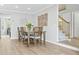 Bright dining room with hardwood floors, a modern table set, and an elegant staircase at 10052 Sage Sparrow Ct, Highlands Ranch, CO 80129