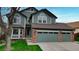Attractive two-story home with a well-maintained lawn, brick accents, and a two-car garage at 10052 Sage Sparrow Ct, Highlands Ranch, CO 80129