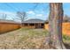 View of the home's backyard with new fence, mature tree, and well-maintained lawn at 1320 Locust St, Denver, CO 80220
