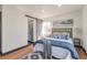 Comfortable bedroom featuring a barn door to a shower room, wood floors and ample light at 1320 Locust St, Denver, CO 80220