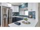 Modern kitchen with blue cabinets, white countertops, stainless steel appliances, and green tile backsplash at 1320 Locust St, Denver, CO 80220