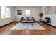 Bright living room with hardwood floors, a gray sofa, patterned rug and a small accent table at 1320 Locust St, Denver, CO 80220
