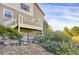 A backyard view showing the deck, stone landscaping and lush greenery at 8835 Edinburgh Cir, Highlands Ranch, CO 80129