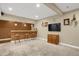 Finished basement with a bar, stools, TV, carpeted floors, and recessed lighting at 8835 Edinburgh Cir, Highlands Ranch, CO 80129