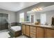 Elegant bathroom features a double vanity, soaking tub, glass-enclosed shower, and neutral colors at 8835 Edinburgh Cir, Highlands Ranch, CO 80129