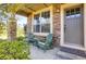 Inviting front porch with stone accents, comfy chairs, and a 'Welcome' mat at 8835 Edinburgh Cir, Highlands Ranch, CO 80129