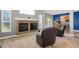 Open living room with a cozy fireplace and comfortable leather recliners at 8835 Edinburgh Cir, Highlands Ranch, CO 80129