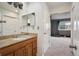 Bathroom view of a wood vanity with granite counter, and the bedroom can be seen through the doorway at 4117 S Mobile Cir # C, Aurora, CO 80013
