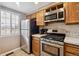 This kitchen has stainless steel appliances, tile flooring, wood cabinets, and a bright window providing natural light at 4117 S Mobile Cir # C, Aurora, CO 80013