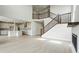 Bright living room showcasing the staircase, kitchen, fireplace and a light wood floor at 5722 Farrier Pt, Castle Rock, CO 80104