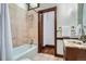 Clean bathroom with tiled shower/tub, marble vanity, and decorative towel racks at 320 E Dakota Ave, Denver, CO 80209