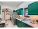 Updated kitchen with green cabinets, stainless steel appliances, and tiled flooring at 320 E Dakota Ave, Denver, CO 80209