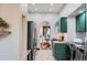 Galley kitchen boasts stainless appliances, green cabinets, and washer/dryer combo, leading to dining area at 320 E Dakota Ave, Denver, CO 80209