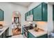 Bright kitchen with updated appliances and green cabinetry, open to the dining area at 320 E Dakota Ave, Denver, CO 80209