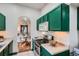 Updated kitchen open to the dining area with stainless steel appliances and green cabinetry at 320 E Dakota Ave, Denver, CO 80209
