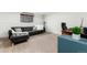 Finished basement features neutral carpet, a modern desk, and comfortable black leather sofa with accent pillows at 1419 Dexter St, Denver, CO 80220
