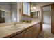 Bathroom with double sinks, wood cabinets, and a shower with glass door at 2191 Baldy Ln, Evergreen, CO 80439