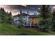 Exterior of a gray home with a deck, large windows, and lush green landscaping at 2191 Baldy Ln, Evergreen, CO 80439