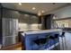 Stylish kitchen featuring gray cabinets, stainless steel appliances, and a sleek breakfast bar with marble countertop at 2191 Baldy Ln, Evergreen, CO 80439