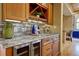 Kitchen wet bar features granite countertops, stainless steel appliances, and wood cabinetry at 2191 Baldy Ln, Evergreen, CO 80439