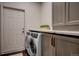 Well-equipped laundry room with modern appliances, sleek cabinets, and a countertop for folding at 2191 Baldy Ln, Evergreen, CO 80439