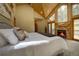 Comfortable main bedroom with a stone fireplace and access to the deck at 2191 Baldy Ln, Evergreen, CO 80439
