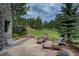 Relax on the outdoor stone patio with comfortable seating and lush landscaped surroundings at 2191 Baldy Ln, Evergreen, CO 80439