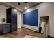 Basement recreation room with storage cabinets, wood floors, mirror, and exercise equipment at 2191 Baldy Ln, Evergreen, CO 80439