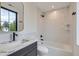 Modern bathroom featuring white subway tiles, bathtub, black fixtures and a marble countertop vanity at 3019 Chase St, Wheat Ridge, CO 80214
