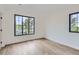 Well-lit bedroom featuring hardwood floors, large windows, and a minimalist design creates a serene and comfortable atmosphere at 3019 Chase St, Wheat Ridge, CO 80214