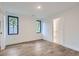 Bright bedroom features light wood floors, white walls, and black trim windows offering natural light at 3019 Chase St, Wheat Ridge, CO 80214