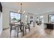 Bright dining room with large windows, hardwood floors and modern chandelier, adjacent to the living area at 3019 Chase St, Wheat Ridge, CO 80214